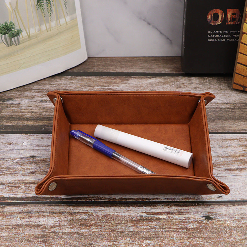 Brown leather organizer tray with folded and flat views, featuring metal rivets and key display