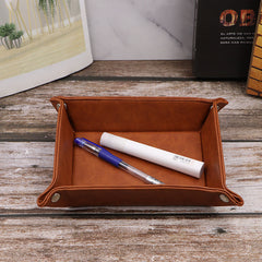 Brown leather organizer tray with folded and flat views, featuring metal rivets and key display